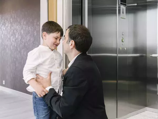 Père et son fils dans le palier à côté de l’ascenseur Orona